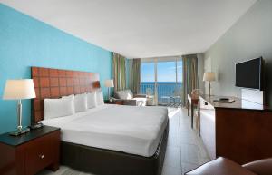 a hotel room with a bed and a view of the ocean at Crown Reef Beach Resort and Waterpark in Myrtle Beach +56 photos