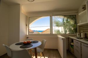 a small kitchen with a table and a window at Apartments Petar Maksan in Pakoštane +58 photos