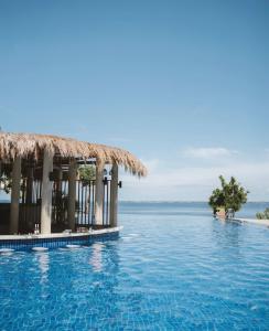 a swimming pool with the ocean in the background at Ocean View Escape at The Mactan Newtown in Punta Engaño