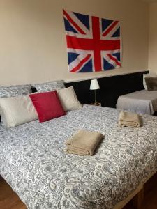 a bed with two pillows and a flag on the wall at Amis Wine House - Maison d'hôtes à 5 min de Saint-Émilion in Pomerol
