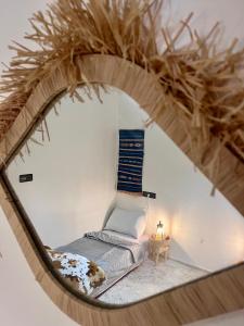 a mirror reflecting a bed in a room at Surf Apartment in Tamri Rooftop Local Experience in Tamri