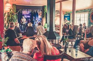 a group of people sitting in a bar listening to a speaker at The Hangklip Hotel in Pringle Bay
