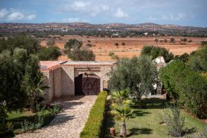 a stone building with a gate in a field at La Vida Surf - Yoga Villa in Ounara