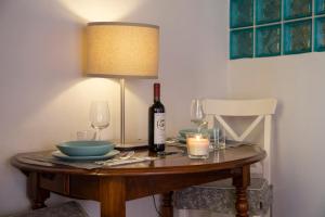 a table with a bottle of wine and a lamp at Rio Marina central apartment- 200m dal mare in Rio Marina