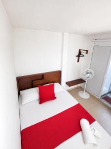 a bedroom with a red and white bed and a window at KOKOA GARDEN INN in San Vicente de Chucurí