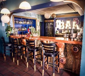 a bar with a wooden counter and some chairs at The Hangklip Hotel in Pringle Bay