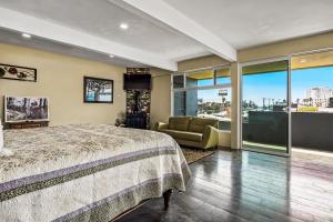 a bedroom with a bed and a couch and windows at Tropical Retreat with Ocean Views - Steps from the sand with alfresco dining in Rosarito +38 photos