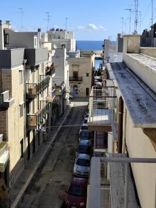 an empty street with cars parked on the sides of buildings at PESCIOLINO B&B in Mola di Bari
