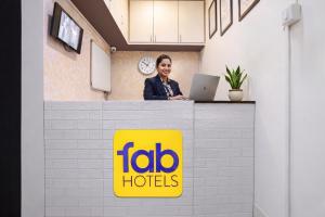 a man sitting at a counter with a laptop at FabHotel Marvey Residency in Mumbai