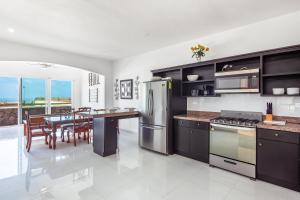 a kitchen with stainless steel appliances and a dining table at Dog-Friendly Ocean-View Home with Heated Outdoor Pool, Hot Tub, Streaming, Patio in Rosarito
