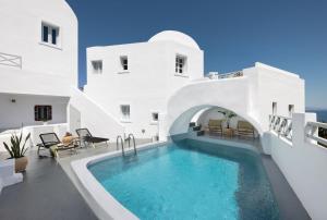 a swimming pool in the middle of a white house at Elios Cave Suites in Oia