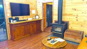 a living room with a stove and a tv at Bellthorpe Retreat in Bellthorpe