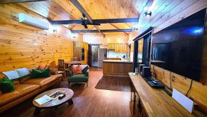 a living room with a couch and a large television at Bellthorpe Retreat in Bellthorpe
