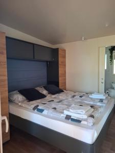 a bedroom with a large bed with a blue headboard at Mobile Home Drage Tara in Drage