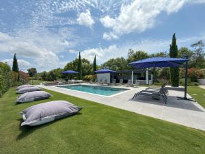a pool with pillows and umbrellas on the grass at Villa Athos in Corfu