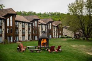a large building with chairs and a fireplace in the grass at Hotel Lac Carling Spa Golf in Harrington
