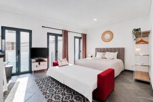a hotel room with two beds and a television at Studio - Old Town Albufeira in Albufeira