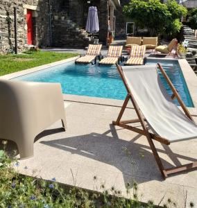 a pool with two lounge chairs and a hammock next to a pool at Refúgio no Douro in Nogueira