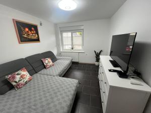 a small living room with a couch and a television at Hiša Čebron in Podnart
