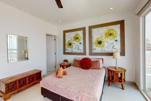 a bedroom with a bed and two paintings on the wall at Dog-Friendly Villa with Heated Outdoor Pool, Hot Tub, Streaming, Partial Views in Rosarito +34 photos
