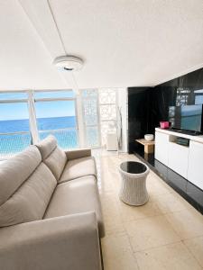 a living room with a couch and a view of the ocean at Apartamento Benidorm primera linea in Benidorm