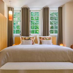 a bedroom with a large bed with two windows at Villa MONTGOMMERY in Saint-Jean-le-Thomas