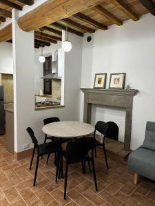 a dining room with a table and chairs and a fireplace at Il Nido in Anghiari
