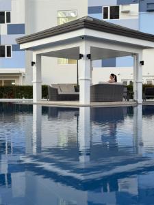 a person sitting in a gazebo next to a swimming pool at Maison Angela Suites in Biñan