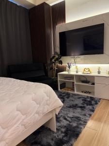 a bedroom with a bed and a flat screen tv at Maison Angela Suites in Biñan +13 photos