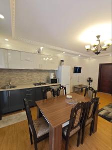 a kitchen with a wooden table and a table and chairs at Luka & Eka in Kobuleti