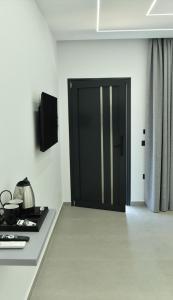 a kitchen with a black door in a room at Grand Avelor Hotel in Vlorë