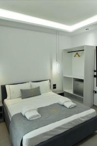 a white bedroom with a large bed with pillows at Grand Avelor Hotel in Vlorë +113 photos