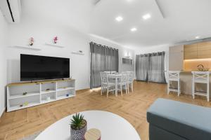 a living room with a tv and a table with chairs at Villa LanaB - Private Pool - by Istrabook in VeliGolji