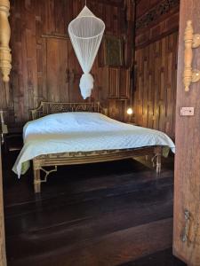 a bedroom with a bed with a net at Teak House Homestay II in Ban Thung Satong