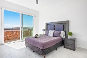 a bedroom with a large bed and a large window at Dog-Friendly Home with Heated Pool, Hot Tub, Partial Ocean Views & Balcony in Rosarito +31 photos