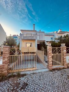 a house with a gate in front of a house at Gama Barros 22 in Charneca