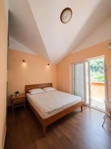 a bedroom with a bed and a large window at Rafailovici Sea View in Rafailovici