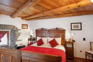 a bedroom with a large wooden bed with red sheets at Locanda delle Miniere in Ollomont