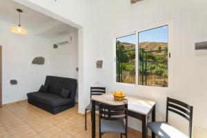 a living room with a table and chairs and a couch at Palmeral de Taidía in Taidía