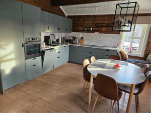 a kitchen with a white table and a table and chairs at Jegertråkket 13 in Sør-Fron