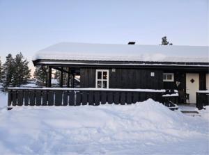 a house covered in snow with a pile of snow at Jegertråkket 13 in Sør-Fron