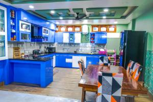 a blue kitchen with a wooden table and blue cabinets at Daisy Homestay Dirang in Dirang Dzong