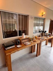 a long wooden table with food on it in a room at Pousada Safari do Jaguar in Poconé
