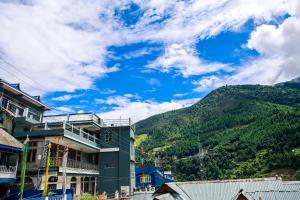 a building with a mountain in the background at Daisy Homestay Dirang in Dirang Dzong