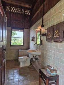 a bathroom with a toilet and a sink at Teak House Homestay II in Ban Thung Satong +21 photos