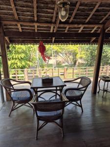 a patio with a table and chairs on a porch at Teak House Homestay II in Ban Thung Satong