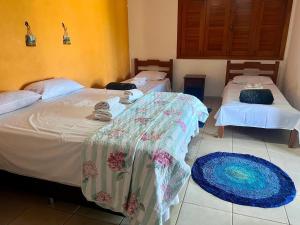 two beds in a room with mats on the floor at Pousada Recanto Guará Oficial in Pirenópolis +16 photos