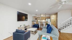 a living room with blue chairs and a kitchen at Salt Pond --- 38435 Mainsail Dr #9 in Bethany Beach