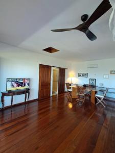 a living room with a ceiling fan and a table at Villa Orita in Nosy Be