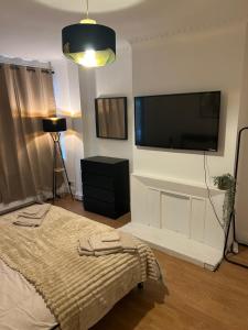 a bedroom with a bed and a flat screen tv at Newly Refurbished House in Norwood